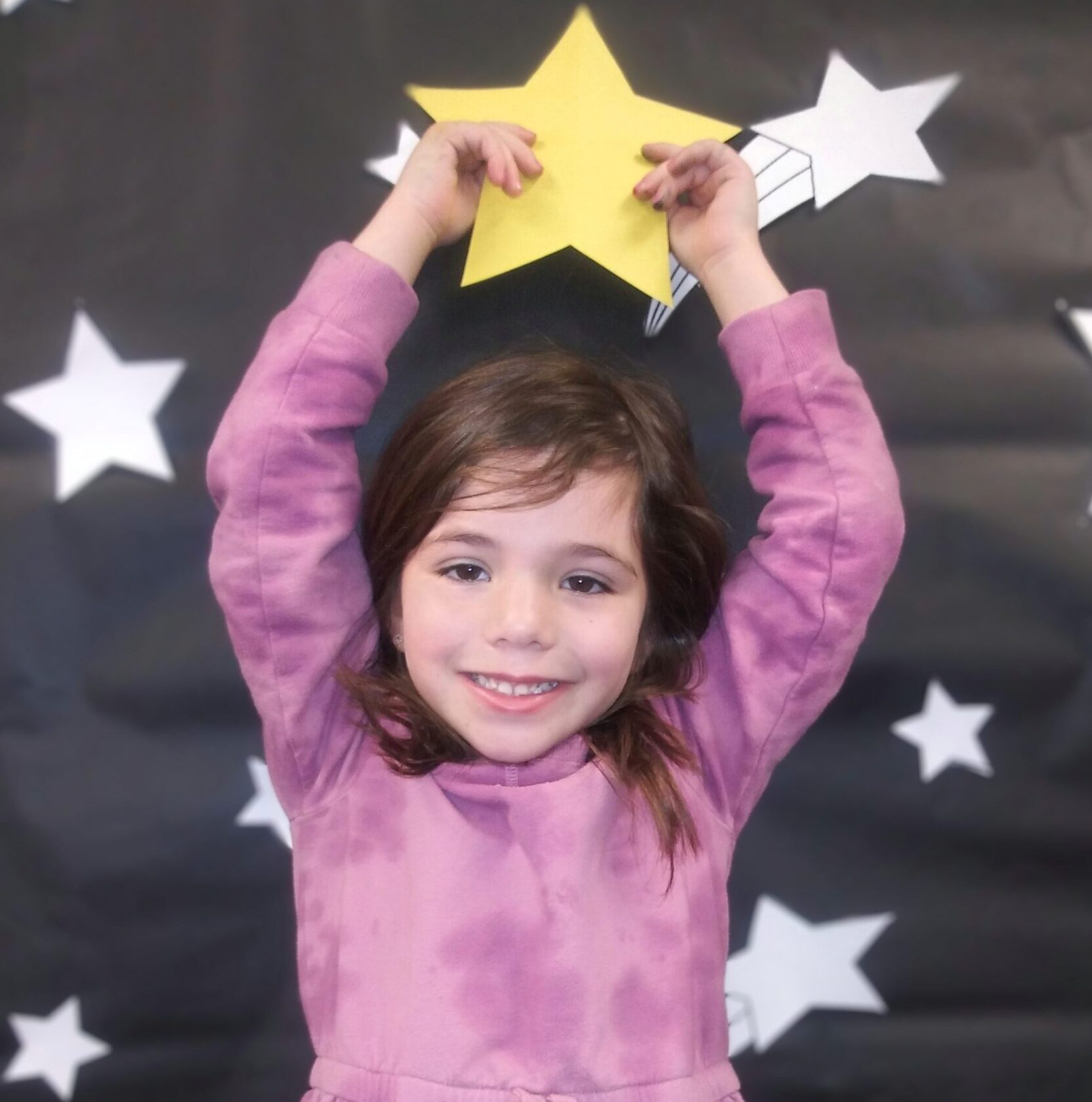 Girl holding star with star background