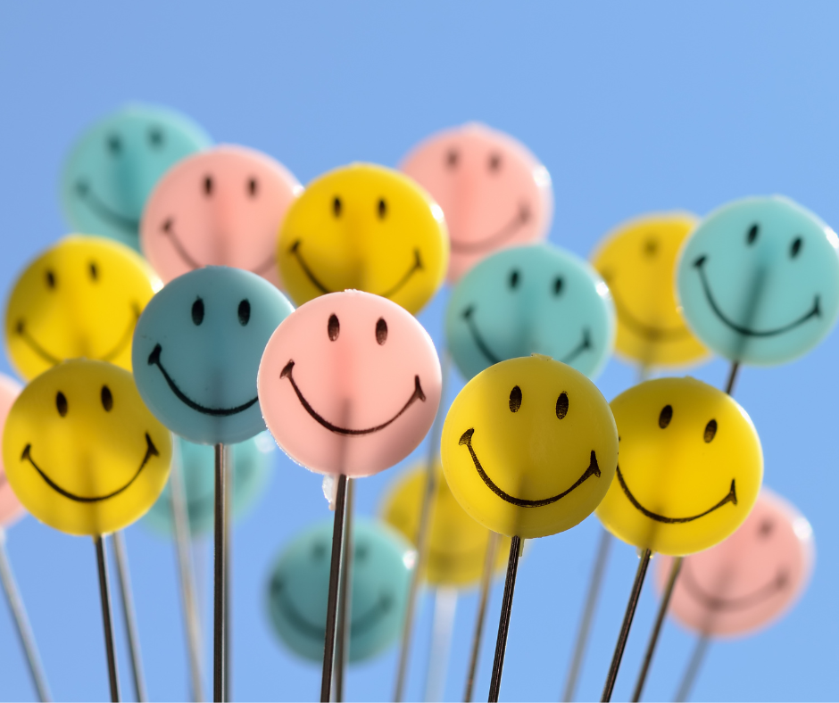 A bunch of pink, blue, and yellow smiley face lollipops