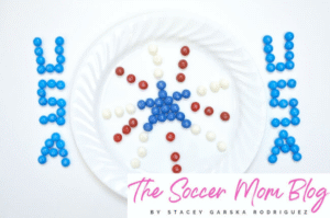 Red, white, and blue skittles arranged in a firework pattern on a white plate