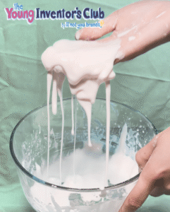 hands lifting oobleck out of a clear bowl