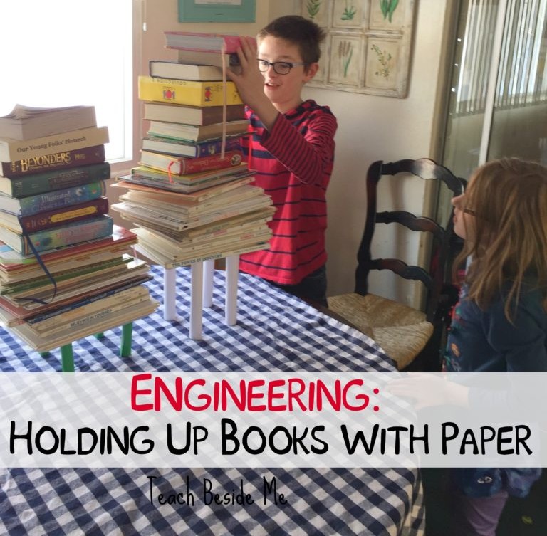 Boy building a table out of paper to hold up books